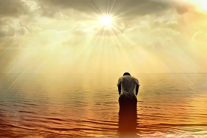 Man praying at the ocean
